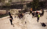 Des membres des forces de sécurité israéliennes se trouvent sur les lieux où un fragment de missile balistique iranien intercepté s'est écrasé dans le quartier juif de la Vieille Ville de Jérusalem le 20 mars 2026, endommageant une route et un mur. (Crédit : Porte-parole de Tsahal)