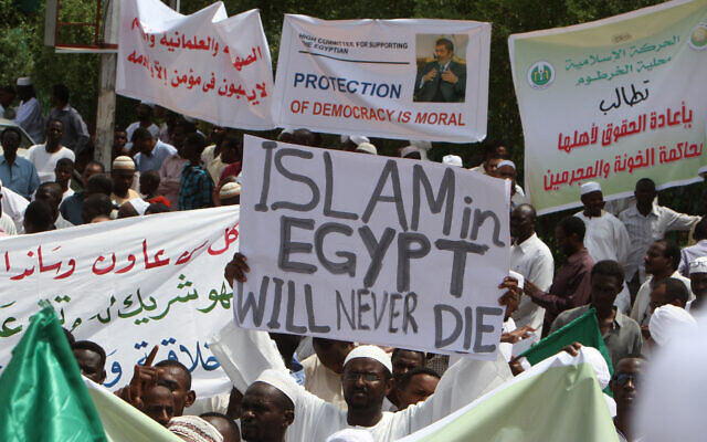 Des partisans soudanais des Frères musulmans et du président égyptien déchu Mohamed Morsi manifestent après la prière du vendredi midi devant le palais présidentiel de la capitale Khartoum, le 16 août 2013, à la suite des récentes violences en Égypte. Cette manifestation fait suite à la mort de 578 personnes le 14 août lors d'affrontements dans la capitale égyptienne, Le Caire, alors que la police dispersait deux camps de protestataires pro-Morsi, ainsi qu'ailleurs dans le pays, lors de la journée la plus sanglante que l'Égypte ait connue depuis une dizaine d'années. (Crédit : Ashraf Shazly/AFP)
