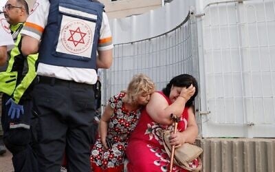 Photo d'illustration : Des équipes de secours viennent en aide à des habitants sous le choc dans un quartier résidentiel pris pour cible dans la ville d'Ashkelon, dans le sud du pays, le 11 mai 2021, après des tirs de roquettes lancés par le Hamas depuis la bande de Gaza. (Crédit : JACK GUEZ / AFP)
