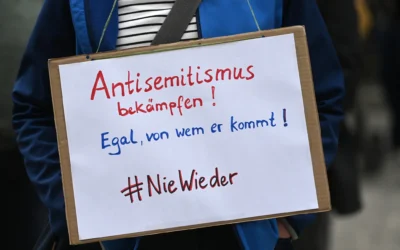 Un membre de l’Initiative contre l’antisémitisme de Gelsenkirchen brandit une pancarte sur laquelle on peut lire « Combattre l’antisémitisme – Peu importe d’où il vient – #plus jamais ça » lors d’une veillée devant la synagogue de Gelsenkirchen, dans l’ouest de l’Allemagne, le 14 mai 2021. (Crédit : Ina FASSBENDER/AFP) Un membre de l’Initiative contre l’antisémitisme de Gelsenkirchen brandit une pancarte sur laquelle on peut lire « Combattre l’antisémitisme – Peu importe d’où il vient – #plus jamais ça » lors d’une veillée devant la synagogue de Gelsenkirchen, dans l’ouest de l’Allemagne, le 14 mai 2021. (Crédit : Ina FASSBENDER/AFP)