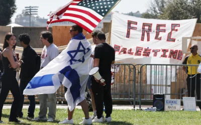 Un contre-manifestant porte un drapeau israélien tout en brandissant un drapeau américain près d’un campement pro-palestinien et anti-israélien sur le campus de l’Université de Californie à Los Angeles (UCLA), le 30 avril 2024 à Los Angeles, en Californie. (Crédit : MARIO TAMA / GETTY IMAGES NORTH AMERICA / Getty Images via AFP)