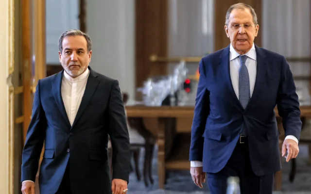Le ministre iranien des Affaires étrangères, Abbas Araghchi (à gauche), et le ministre russe des Affaires étrangères, Sergueï Lavrov, marchent ensemble après leur rencontre pour donner une conférence de presse conjointe au siège du ministère des Affaires étrangères à Téhéran, en Iran, le 25 février 2025. (Crédit : ATTA KENARE / AFP)