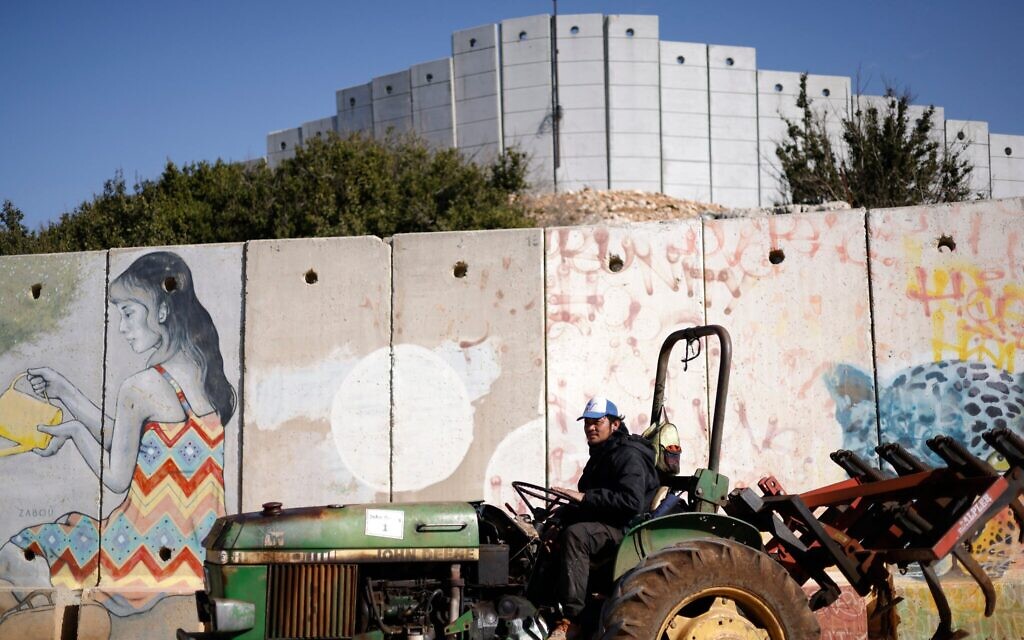 Un travailleur étranger conduisant un tracteur près de Shtula, dans le nord d'Israël, à proximité de la barrière de sécurité à la frontière avec le sud du Liban, le 8 janvier 2026. (Crédit : Jalaa Marey/AFP) Un travailleur étranger conduisant un tracteur près de Shtula, dans le nord d'Israël, à proximité de la barrière de sécurité à la frontière avec le sud du Liban, le 8 janvier 2026. (Crédit : Jalaa Marey/AFP)