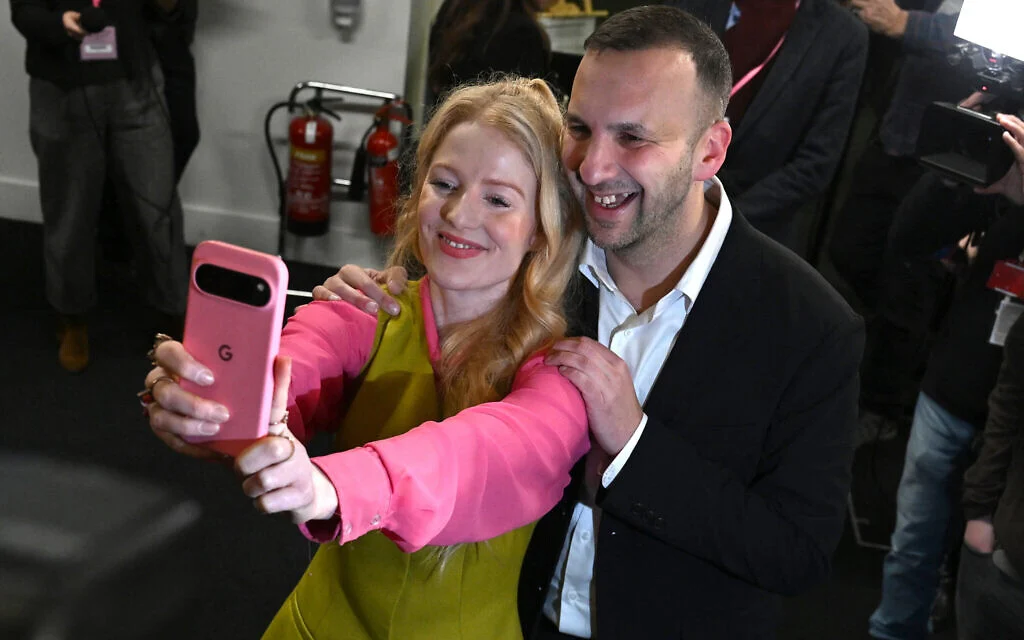 La candidate du Parti vert, Hannah Spencer, fait un selfie avec le chef du Parti vert, Zack Polanski, après sa victoire à l'élection parlementaire partielle de Gorton et Denton, au Manchester Central Convention Complex à Manchester, en Angleterre, le 27 février 2026. (Photo par Paul ELLIS / AFP) La candidate du Parti vert, Hannah Spencer, fait un selfie avec le chef du Parti vert, Zack Polanski, après sa victoire à l'élection parlementaire partielle de Gorton et Denton, au Manchester Central Convention Complex à Manchester, en Angleterre, le 27 février 2026. (Photo par Paul ELLIS / AFP)