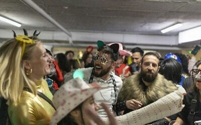 Des Israéliens déguisés rassemblés dans un parking du centre commercial Dizengoff de Tel Aviv utilisé comme abri pour célébrer la fête de Pourim, le 2 mars 2026. (Crédit : Ilia Yefimovich/AFP) Des Israéliens déguisés rassemblés dans un parking du centre commercial Dizengoff de Tel Aviv utilisé comme abri pour célébrer la fête de Pourim, le 2 mars 2026. (Crédit : Ilia Yefimovich/AFP)