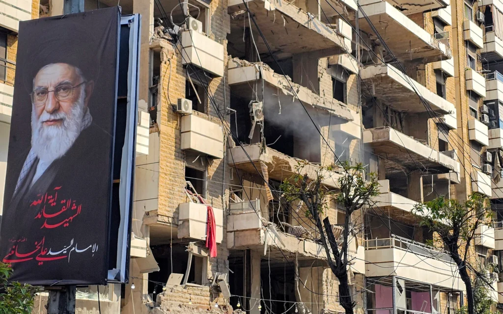 Une bannière du guide suprême iranien, l'ayatollah Ali Khamenei, à côté d'un bâtiment endommagé par une frappe israélienne dans la banlieue sud de Beyrouth, le 3 mars 2026. (Crédit : AFP)