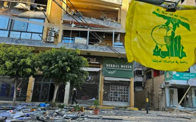 Un drapeau du Hezbollah flottant sur le site de bâtiments détruits à la suite de frappes aériennes dans la banlieue sud de Beyrouth, dans le quartier de Ghobeiry, le 5 mars 2026. (Crédit : AFP)