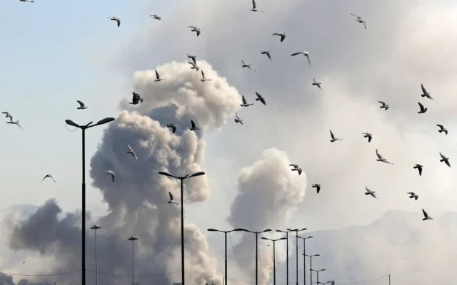 Des oiseaux volent sur fond de fumée s'élevant après une frappe sur la capitale iranienne Téhéran, le 5 mars 2026. (Crédit : ATTA KENARE / AFP)