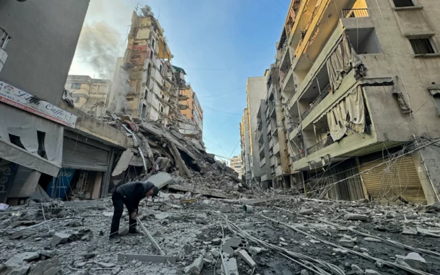 Un homme inspecte les décombres des bâtiments détruits sur le site d'une frappe aérienne israélienne qui visait le Hezbollah dans le quartier de Haret Hreik, dans la banlieue sud de Beyrouth, le 7 mars 2026 (Crédit : AFP)
