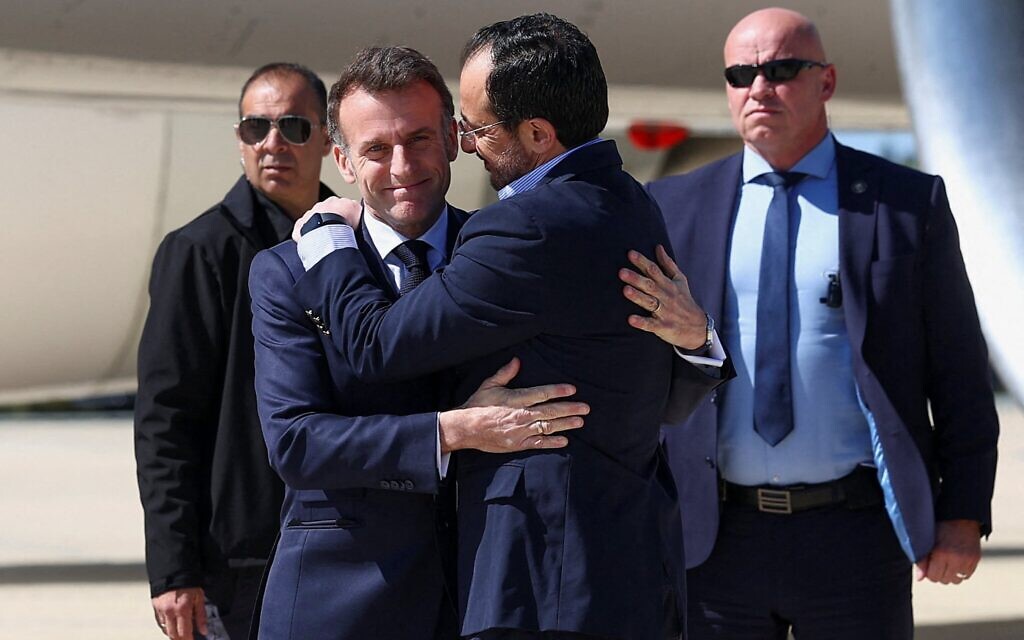 Le président français Emmanuel Macron (à gauche) salue le président chypriote Nikos Christodoulides (à droite) à son arrivée à la base militaire de Paphos, à Chypre, le 9 mars 2026. (Crédit : Gonzalo Fuentes / POOL / AFP)