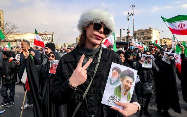 Une femme posant avec une photo du nouveau guide suprême iranien, l'ayatollah Mojtaba Khamenei (à droite), à côté de son défunt père Ali Khamenei, lors d'un rassemblement en son soutien, sur la place Enghelab, dans le centre de Téhéran, le 9 mars 2026. (Crédit : Atta Kenare/AFP)