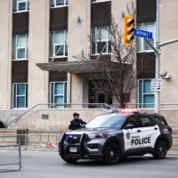 Des agents de police de Toronto interviennent sur les lieux d’une fusillade au consulat américain de Toronto, au Canada, le 10 mars 2026. (Crédit : Cole BURSTON/AFP)