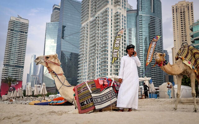 Un chamelier parlant au téléphone à côté d'un chameau sur la plage de Dubaï, le 10 mars 2026. Les pays du Golfe ont longtemps été considérés comme des îlots de stabilité au Moyen-Orient, mais la guerre dans la région pourrait menacer leur prospérité, selon les analystes, qui soulignent les risques pour leurs revenus et leur réputation en tant que paradis commerciaux. (Crédit : Fadel Senna/AFP) Un chamelier parlant au téléphone à côté d'un chameau sur la plage de Dubaï, le 10 mars 2026. Les pays du Golfe ont longtemps été considérés comme des îlots de stabilité au Moyen-Orient, mais la guerre dans la région pourrait menacer leur prospérité, selon les analystes, qui soulignent les risques pour leurs revenus et leur réputation en tant que paradis commerciaux. (Crédit : Fadel Senna/AFP)
