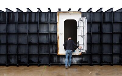 Le responsable de magasin Davis Yarber ouvrant la porte d'un abri de survie à l'usine Atlas Survival Shelters de Sulphur Springs, au Texas, le 7 mars 2026. (Crédit : Mark Felix/AFP)