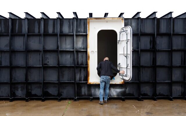 Le responsable de magasin Davis Yarber ouvrant la porte d'un abri de survie à l'usine Atlas Survival Shelters de Sulphur Springs, au Texas, le 7 mars 2026. (Crédit : Mark Felix/AFP)