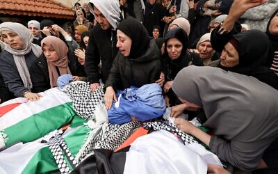 Les proches pleurent devant les dépouilles de quatre membres d'une famille palestinienne, dont deux enfants, tués par les forces israéliennes alors qu'ils se trouvaient dans leur véhicule, lors de leurs funérailles dans la ville de Tammun, en Cisjordanie, le 15 mars 2026. (Crédit : JAAFAR ASHTIYEH / AFP)
