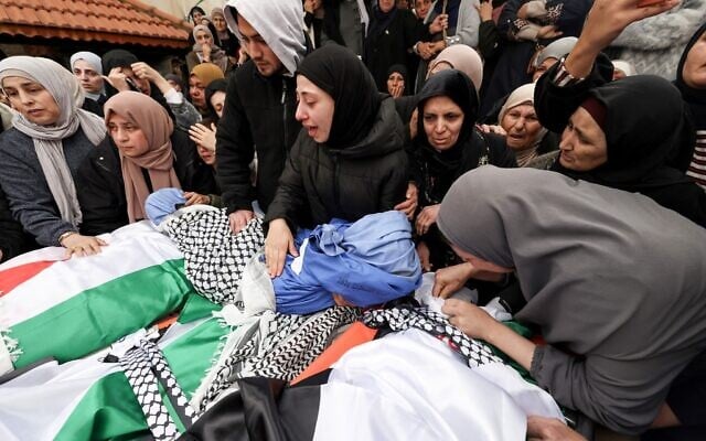 Les proches pleurent devant les dépouilles de quatre membres d'une famille palestinienne, dont deux enfants, tués par les forces israéliennes alors qu'ils se trouvaient dans leur véhicule, lors de leurs funérailles dans la ville de Tammun, en Cisjordanie, le 15 mars 2026. (Crédit : JAAFAR ASHTIYEH / AFP)