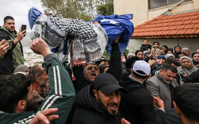 Un membre de la famille porte le corps de Mohammed Bani Odeh, âgé de 5 ans, lors des funérailles d'une famille palestinienne tuée par les forces israéliennes alors qu'elle se trouvait dans son véhicule, dans la ville de Tammun, en Cisjordanie, le 15 mars 2026. (Crédit : JAAFAR ASHTIYEH / AFP)
