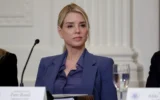La ministre de la Justice américaine Pam Bondi écoute le président américain Donald Trump s'exprimer lors d'un déjeuner dans la Salle Est de la Maison Blanche, le 16 mars 2026 à Washington, DC. (Crédit: ALEX WONG / GETTY IMAGES NORTH AMERICA / Getty Images via AFP)