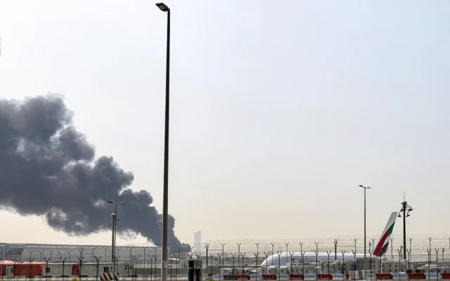 Un panache de fumée s’élève d’un incendie en cours après une attaque apparemment iranienne près de l’aéroport international de Dubaï, le 16 mars 2026 (Crédit : Fadel SENNA/AFP)