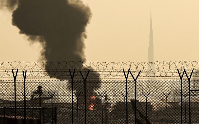 Illustration: La ligne d'horizon de Dubaï, avec l'emblématique gratte-ciel Burj Khalifa (à droite), est photographiée alors qu'un panache de fumée s'élève d'un incendie en cours près de l'aéroport international de Dubaï, aux Émirats arabes unis, le 16 mars 2026. (Crédit : AFP)