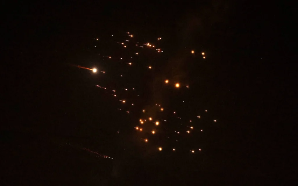 Les sous-munitions d'une bombe visibles dans le ciel au-dessus de Netanya, le 18 mars 2026. (Credit : Jack Guez/AFP)