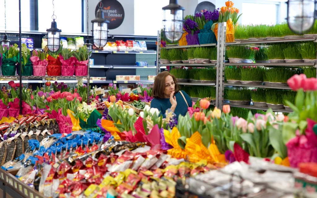 Une femme fait ses achats de sabzeh, une variété d'herbe de blé qui est un élément incontournable des tables du Haft-Sin de Nowruz, tandis que des fleurs sont exposées au Gourmet Bazaar de Rockville, dans le Maryland, le 18 mars 2026, à l'approche de Nowruz, le Nouvel An persan. (Crédit: Amid Farahi/AFP)