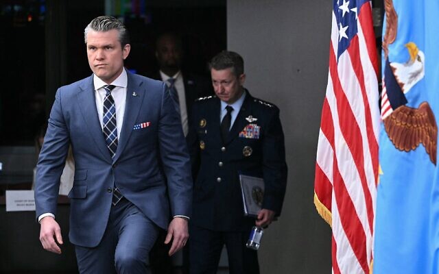 Le secrétaire américain à la Défense Pete Hegseth suivi du président des chefs d’état-major interarmées des États-Unis, le général Dan Caine, arrivant pour une conférence de presse, au Pentagone à Washington, le 19 mars 2026. (Crédit : Mandel Ngan/AFP)