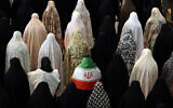 Des femmes chiites iraniennes, dont l'une est drapée dans le drapeau national iranien, participent aux prières de l'Aïd al-Fitr, qui marque la fin du mois sacré musulman du ramadan, à la grande mosquée Mosalla de Téhéran, le 21 mars 2026. (Crédit : AFP)
