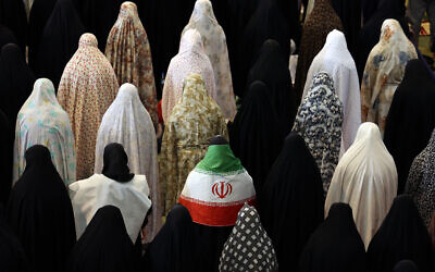 Des femmes chiites iraniennes, dont l'une est drapée dans le drapeau national iranien, participent aux prières de l'Aïd al-Fitr, qui marque la fin du mois sacré musulman du ramadan, à la grande mosquée Mosalla de Téhéran, le 21 mars 2026. (Crédit : AFP)