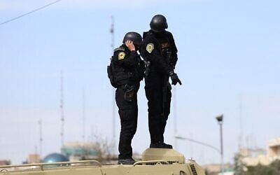 Des forces de sécurité iraniennes montant la garde sur le toit d'un véhicule blindé lors des funérailles du porte-parole du Corps des Gardiens de la Révolution islamique (CGRI), le bras armé du régime iranien, Ali Mohammad Naini, tué lors de frappes américano-israéliennes, à Téhéran, le 21 mars 2026. (Crédit : AFP)