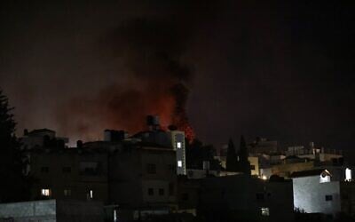 Des flammes et de la fumée s'élevant des maisons et des véhicules en feu, alors que des informations font état d'une attaque menée par des résidents d'implantations, dans le village de Deir al-Hatab, à l'est de Naplouse en Cisjordanie, le 22 mars 2026. (Crédit : Zain Jaafar/AFP)