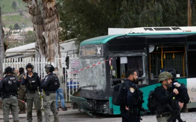 Les forces de sécurité israéliennes se rassemblent sur le site d’un tir de missile du Hezbollah qui a visé un bus dans la ville frontalière de Kiryat Shmona, au nord d’Israël, le 23 mars 2026. (Crédit : Jalaa MAREY/AFP)