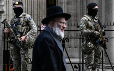 Des militaires belges armés de fusils d'assaut FN SCAR montent la garde devant une synagogue du centre d'Anvers, dans le cadre des mesures de sécurité renforcées mises en place par la Belgique dans les écoles juives et les synagogues, le 23 mars 2026. (Crédit: JOHN THYS / AFP)
