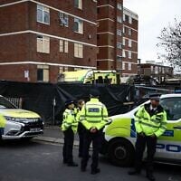 Des policiers se tenant devant les lieux d'un incendie criminel à caractère antisémite, dans le quartier de Golders Green, au nord de Londres, le 24 mars 2026. (Crédit : Henry Nicholls/AFP)