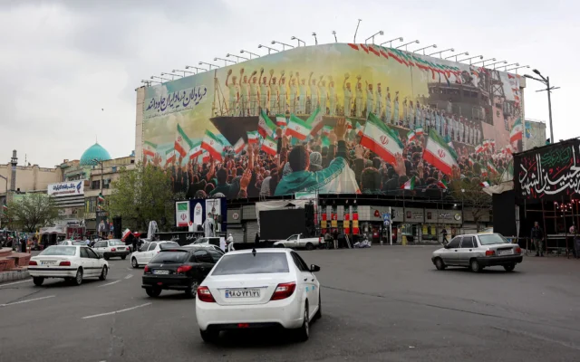 Des véhicules circulent sur la place de la Révolution, dans le centre de Téhéran, en Iran, le 25 mars 2026. (Crédit : AFP)