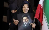Une femme tenant un portrait du guide suprême iranien Mojtaba Khamenei lors d'un défilé de soutien aux forces armées iraniennes, dans le centre de Téhéran, le 25 mars 2026. (Crédit : AFP)