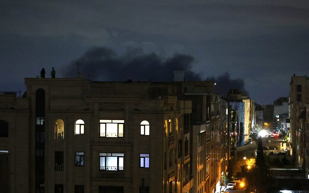 De la fumée s'élevant du lieu d'une frappe, à Téhéran, à l'aube du 28 mars 2026. (Crédit : Atta Kenare/AFP)
