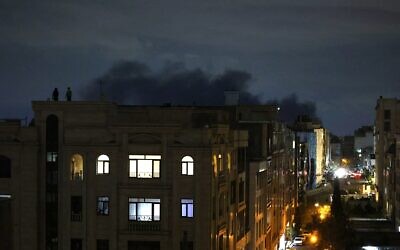 De la fumée s'élevant du lieu d'une frappe, à Téhéran, à l'aube du 28 mars 2026. (Crédit : Atta Kenare/AFP)