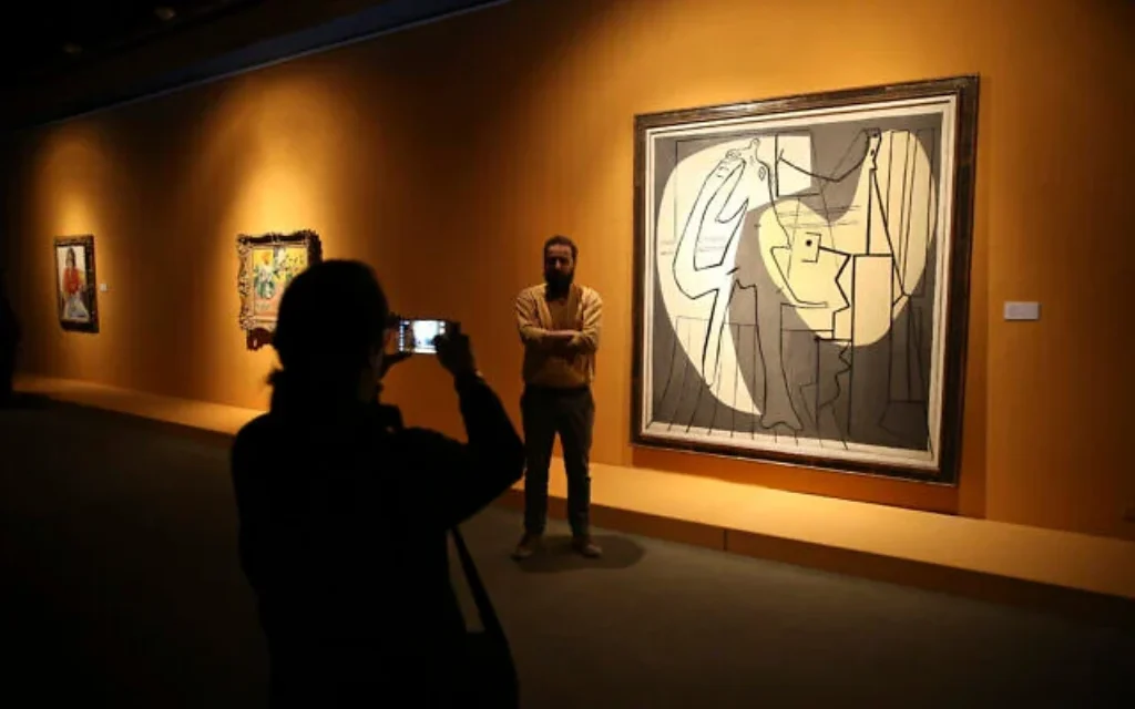 Des visiteurs posent aux côtés du tableau de Pablo Picasso « Le peintre et son modèle », lors d'une exposition au Musée d'Art Contemporain de Téhéran, Iran, le 9 mars 2017. (Photo AP/Vahid Salemi)