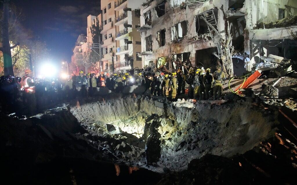 Des officiers du Commandement du Front intérieur fouillant les décombres d’un immeuble endommagé par un missile iranien, à Tel Aviv, tôt le matin du 1ᵉʳ mars 2026. (Crédit: Ohad Zwigenberg/AP Photo) Des officiers du Commandement du Front intérieur fouillant les décombres d’un immeuble endommagé par un missile iranien, à Tel Aviv, tôt le matin du 1ᵉʳ mars 2026. (Crédit: Ohad Zwigenberg/AP Photo)