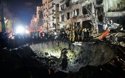 Des officiers du Commandement du Front intérieur fouillant les décombres d’un immeuble endommagé par un missile iranien, à Tel Aviv, tôt le matin du 1ᵉʳ mars 2026. (Crédit: Ohad Zwigenberg/AP Photo)