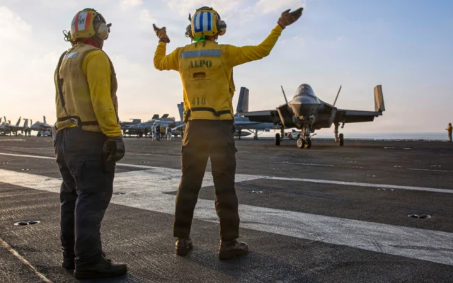 Cette image fournie par le Commandement central américain montre des marins de la marine américaine faisant signe à un F-35C Lightning II sur le pont d'envol de l'USS Abraham Lincoln (CVN 72) lors d'opérations de soutien à la guerre en Iran, le 3 mars 2026. (Crédit : US Navy via AP)