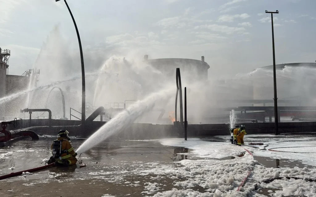 Illustration : Des pompiers en train d'éteindre les flammes après qu'un projectile iranien a frappé une zone industrielle, à Maameer, à Bahreïn, le 9 mars 2026. (Crédit : Ministère de l'Intérieur de Bahreïn via AP)