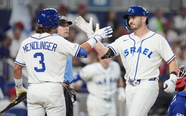 Le frappeur désigné israélien Spencer Horwitz, à droite, est félicité par Noah Mendlinger (3) après avoir réussi un home run contre la République dominicaine lors de la quatrième manche d'un match de la World Baseball Classic, le 9 mars 2026, à Miami. (Crédit : AP Photo/Rebecca Blackwell) Le frappeur désigné israélien Spencer Horwitz, à droite, est félicité par Noah Mendlinger (3) après avoir réussi un home run contre la République dominicaine lors de la quatrième manche d'un match de la World Baseball Classic, le 9 mars 2026, à Miami. (Crédit : AP Photo/Rebecca Blackwell)