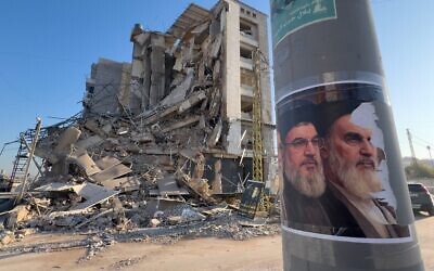 Des portraits de l'ancien chef du groupe terroriste chiite libanais du Hezbollah Hassan Nasrallah et du fondateur de la révolution iranienne, l'ayatollah Khomeini,  devant un bâtiment détruit à Dahiyeh, dans la banlieue sud de Beyrouth, au Liban, le 10 mars 2026. (Crédit : Hussein Malla/AP)