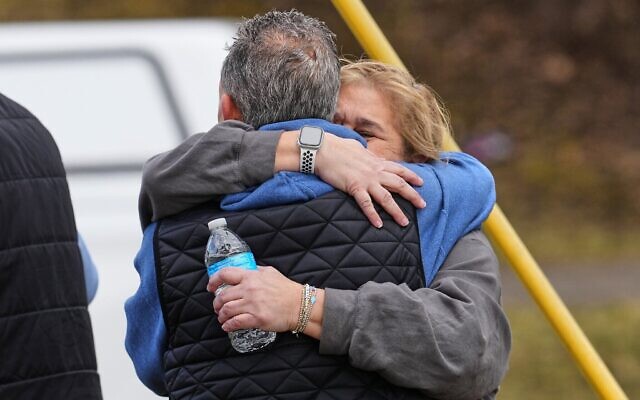 Des personnes s'étreignant tandis que les forces de l'ordre escortent des familles loin de la synagogue Temple Israel, à West Bloomfield Township, dans le Michigan, le 12 mars 2026. (Crédit : Paul Sancya/AP) Des personnes s'étreignant tandis que les forces de l'ordre escortent des familles loin de la synagogue Temple Israel, à West Bloomfield Township, dans le Michigan, le 12 mars 2026. (Crédit : Paul Sancya/AP)