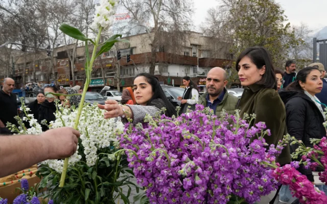 Une femme achète des fleurs à l'approche du Nouvel An persan, ou Nowruz, dans le nord de Téhéran, en Iran, le 19 mars 2026. (Crédit :  AP/Vahid Salemi)