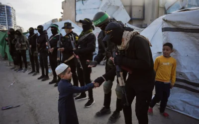 Des terroristes armés du Hamas et du Jihad islamique palestinien saluant les fidèles rassemblés pour la prière de l'Aïd al-Fitr, à Gaza-City, le 20 mars 2026. (Crédit : Abdel Kareem Hana/AP)