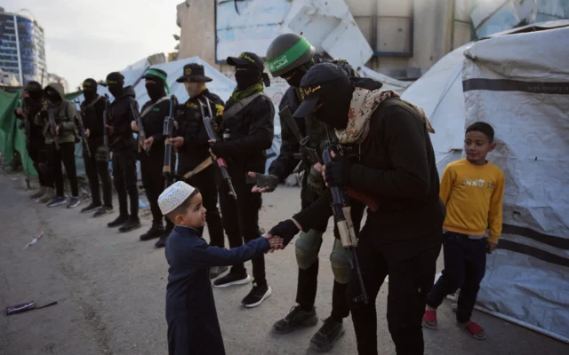 Des terroristes armés du Hamas et du Jihad islamique palestinien saluant les fidèles rassemblés pour la prière de l'Aïd al-Fitr, à Gaza-City, le 20 mars 2026. (Crédit : Abdel Kareem Hana/AP) Des terroristes armés du Hamas et du Jihad islamique palestinien saluant les fidèles rassemblés pour la prière de l'Aïd al-Fitr, à Gaza-City, le 20 mars 2026. (Crédit : Abdel Kareem Hana/AP)